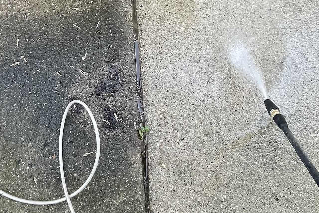 Pressure washer stripping dirt off concrete