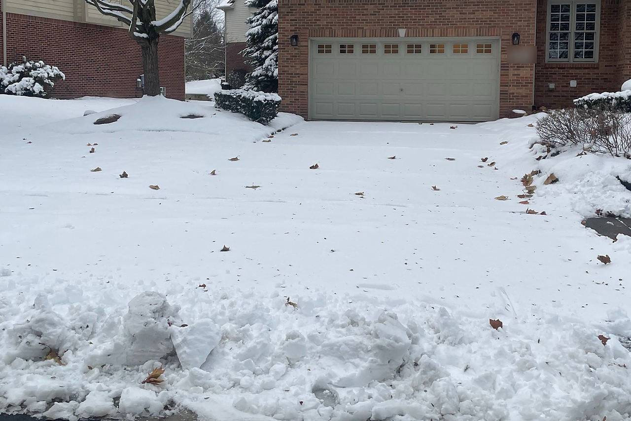 Driveway buried under snow before clearing