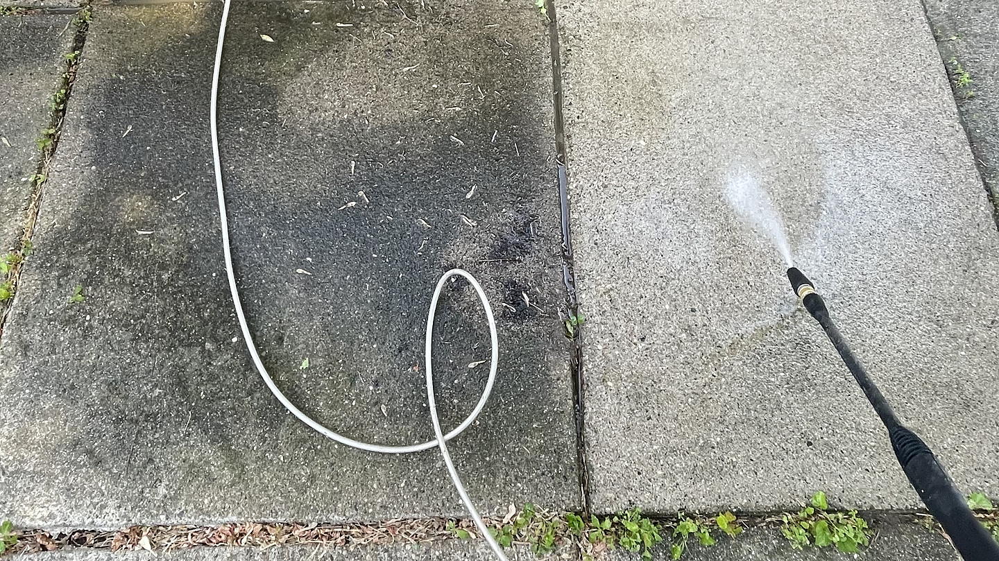Pressure washing a walkway, half cleaned